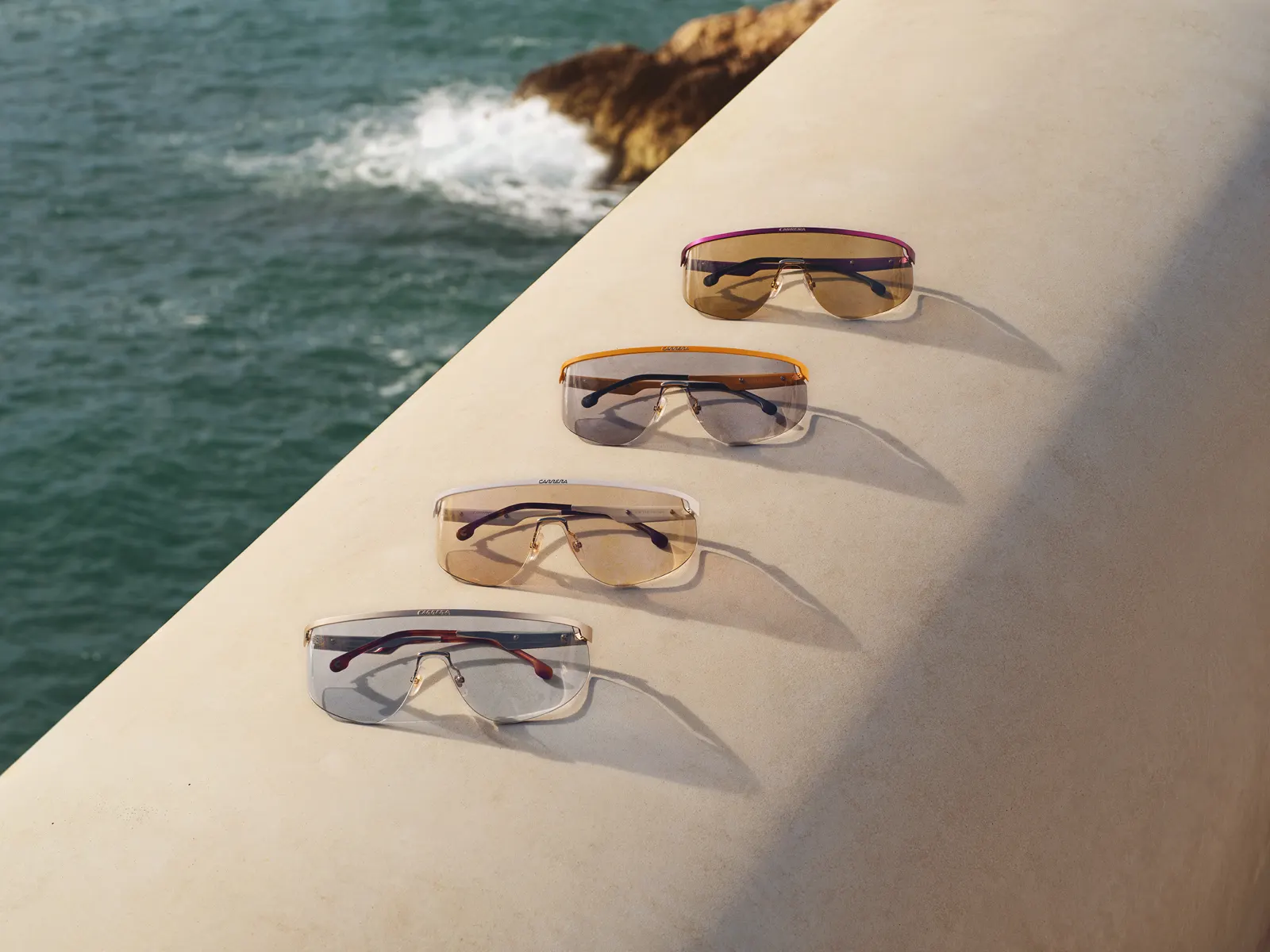 Gafas Carrera FlagLab 19 shield multicolor sobre muro junto al mar